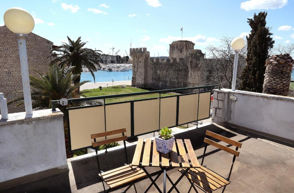 een balkon met twee banken en een kasteel bij MY DALMATIA - M Apartment Trogir with free parking and roof terrace in Trogir