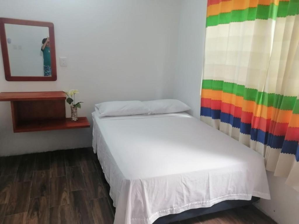 1 dormitorio con 1 cama con cortina de arco iris en Casa shambieda en Santa Cruz - Huatulco