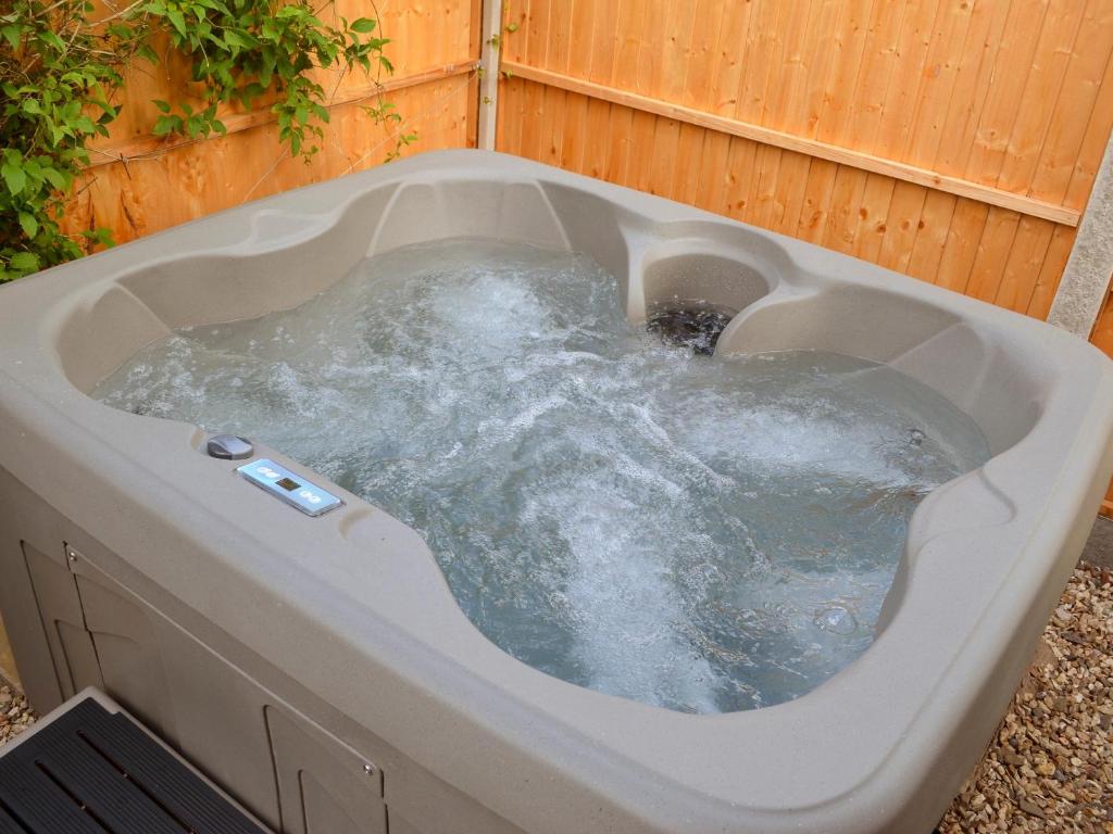 a hot tub with water in it in a backyard at Castle Clover in Bridgnorth