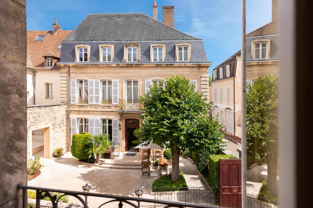 a large house with a courtyard in front of it at L'Hôtel in Beaune