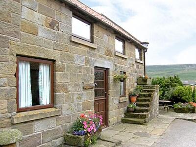 a stone building with a door and some flowers at Valencourt - 18426 in Rosedale Abbey