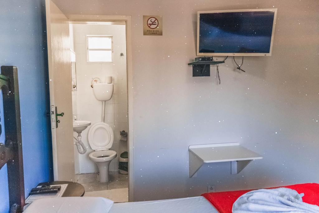 a bathroom with a toilet and a sink on the wall at Diamantina Palace Hotel in Morro do Chapéu