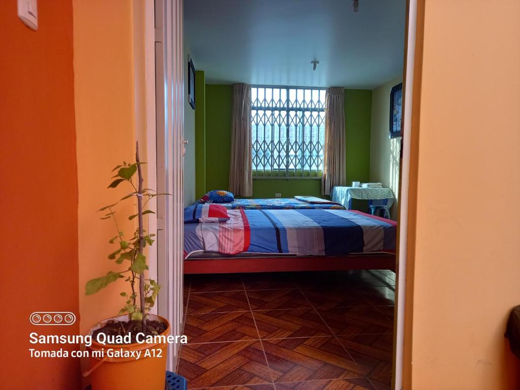 een slaapkamer met een bed in een kamer met groene muren bij Casa Hospedaje San Miguel in Trujillo
