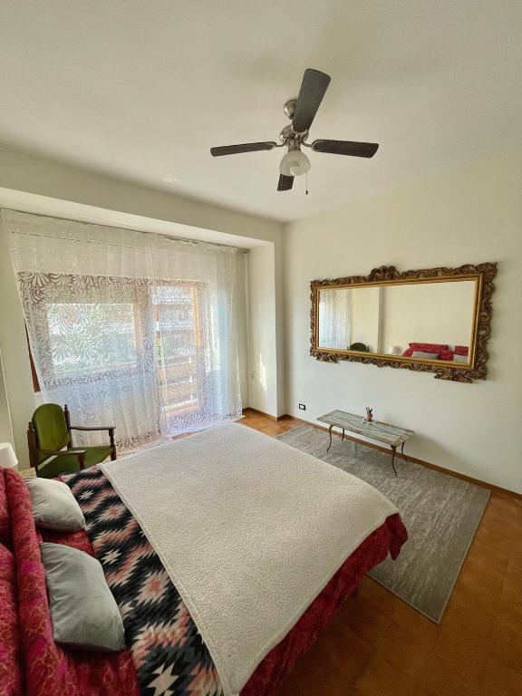 Sunny House في روما: غرفة نوم مع سرير مع مروحة سقف ومرآة