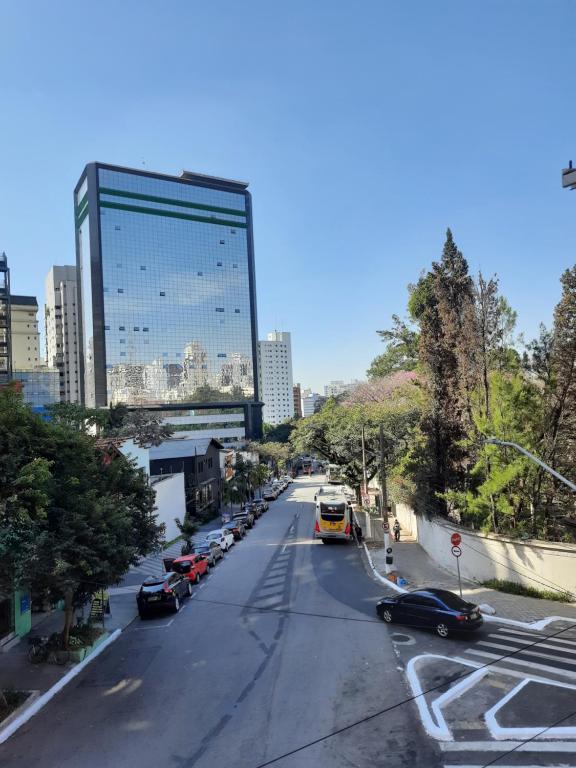 uma rua da cidade com carros e um edifício alto em Hotel sany - Localizado à 5 minutos do Metrô Paulista em São Paulo