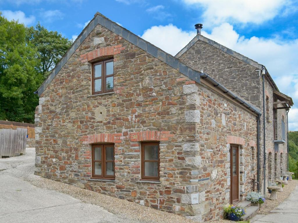 an old stone building with windows on the side at Apple Tree Cottage -18512 in Kilkhampton