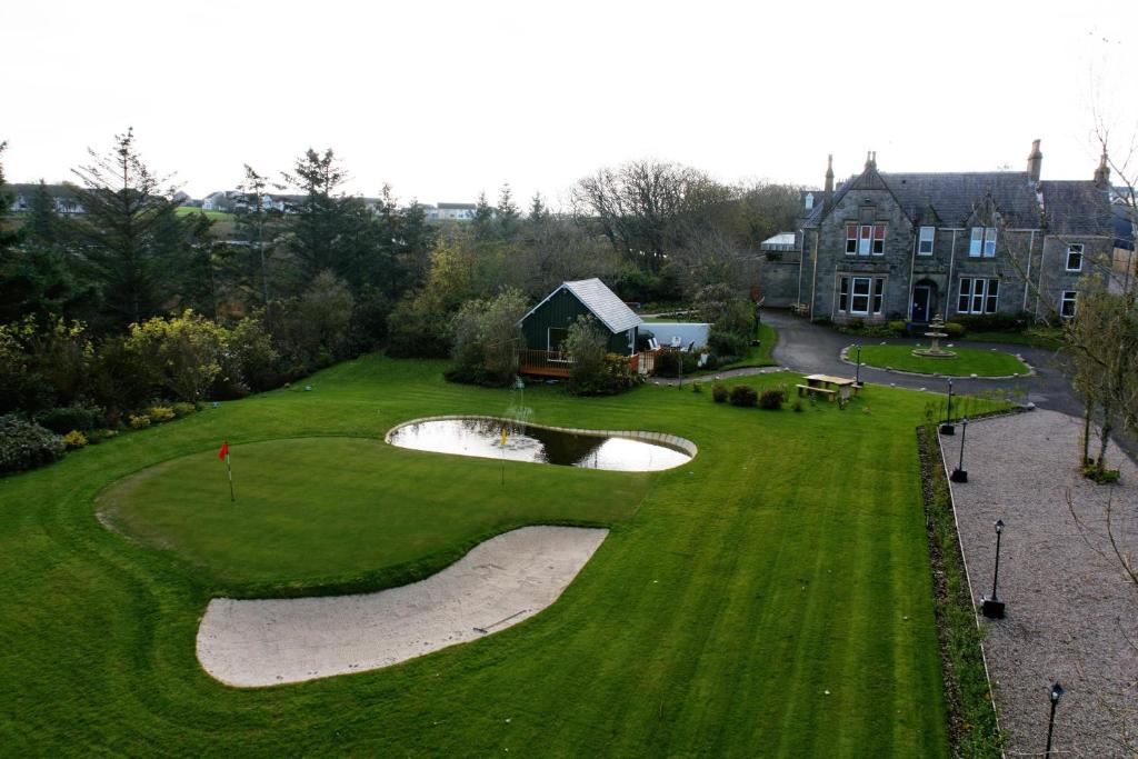 an aerial view of a golf course with a house at Camfield House in Thurso