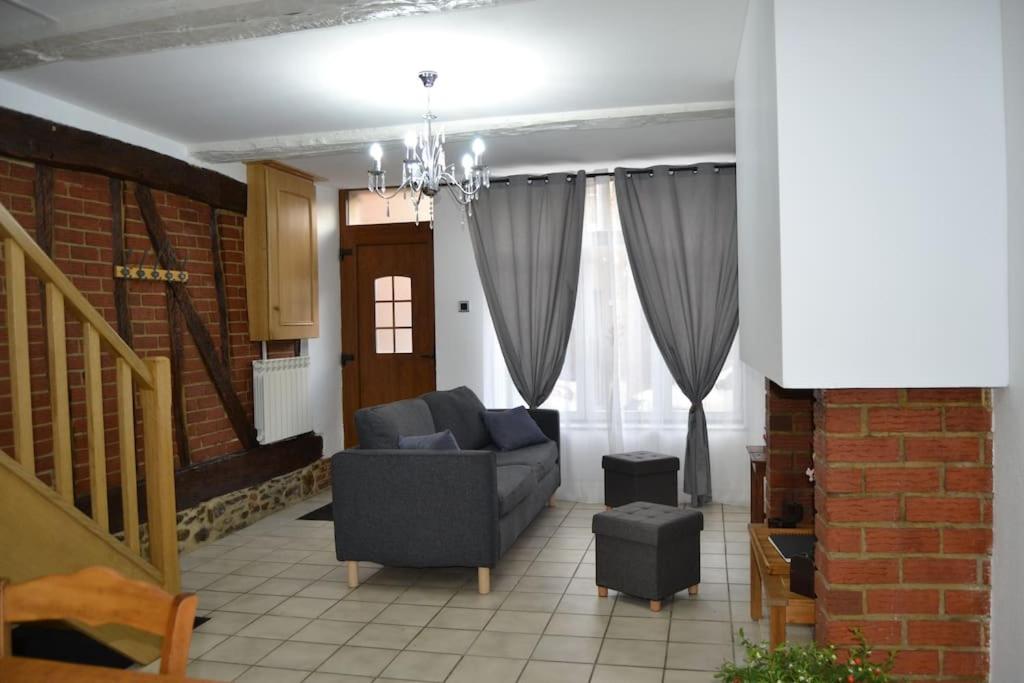 a living room with a couch and a chandelier at L'Escale des remparts in Rocroi