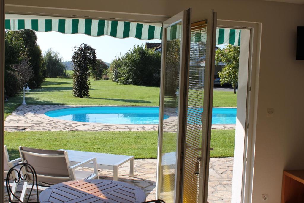 a view of a pool through a sliding glass door at Agora in Foussemagne