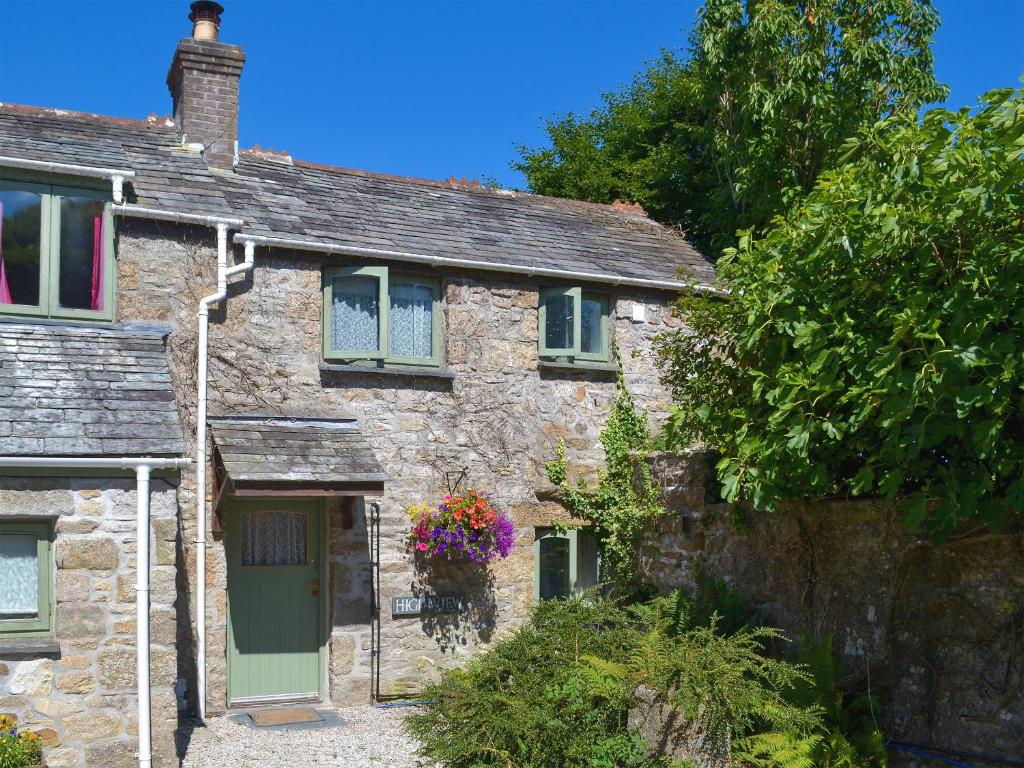 an old stone cottage with a green door at High View in Saint Breward