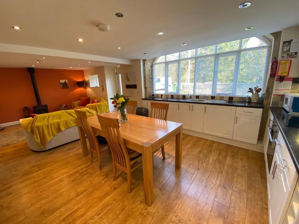 a kitchen and dining room with a wooden table and chairs at Oak Tree Barn - 27693 in Otterburn