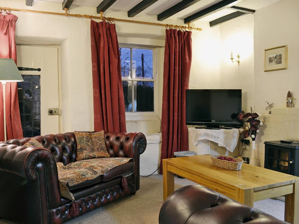 a living room with a couch and a tv at Pats Cottage in Dore