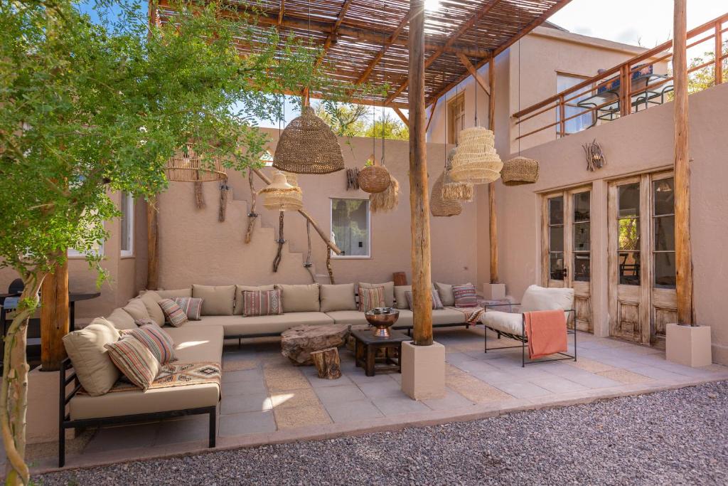 a patio with a couch and chairs and a table at Casa Solcor Boutique Bed & Breakfast in San Pedro de Atacama