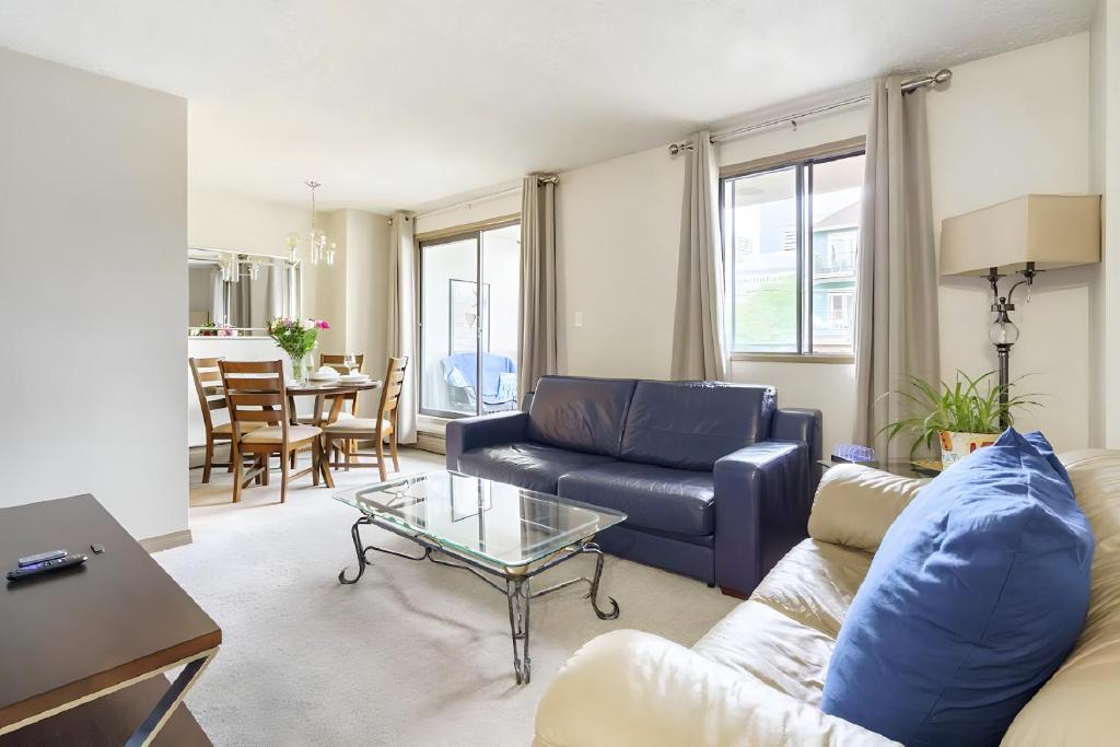 a living room with a couch and a table at Entire Condo Downtown, walk to BMO & Stampede, Parking, 1,5 hrs to Banff in Calgary