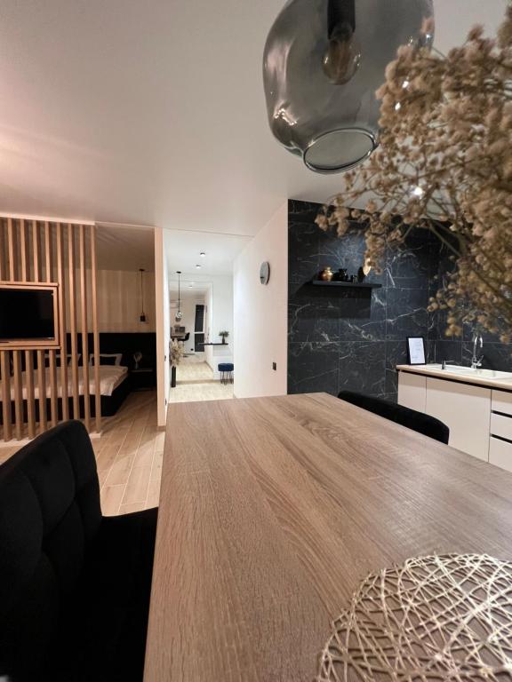 kuchnia i salon z dużym drewnianym stołem w obiekcie Апартаменти центр Чортків w mieście Chortkiv