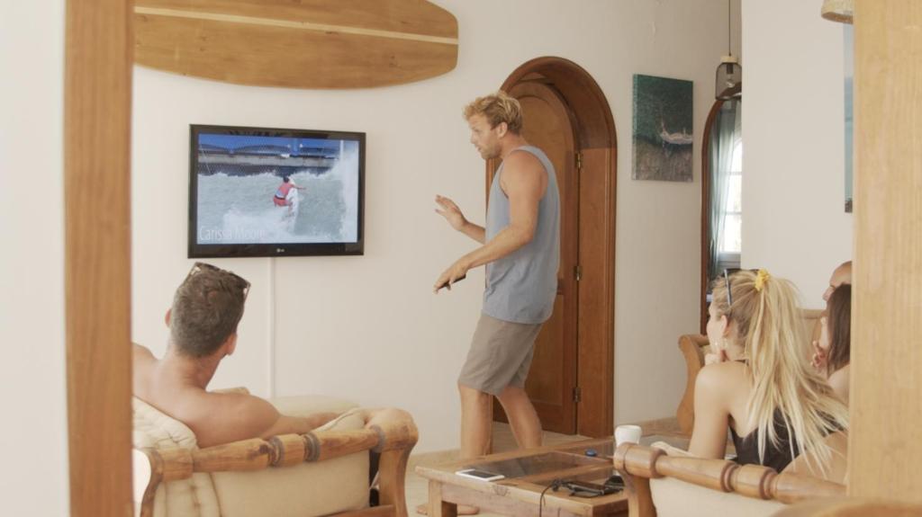 a man standing in a room with a group of people at Pura Vida Surf Camp & School in La Oliva