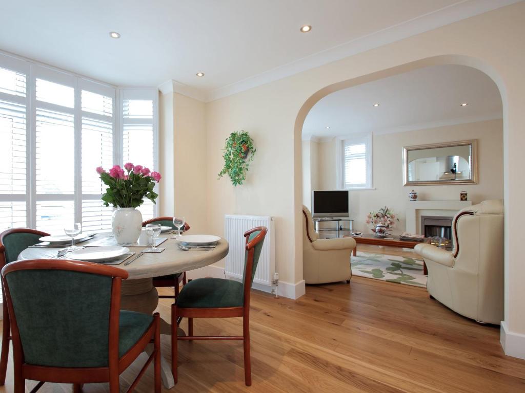 una sala da pranzo con tavolo e sedie e un soggiorno di The Avoncliffe Bournemouth a Southbourne