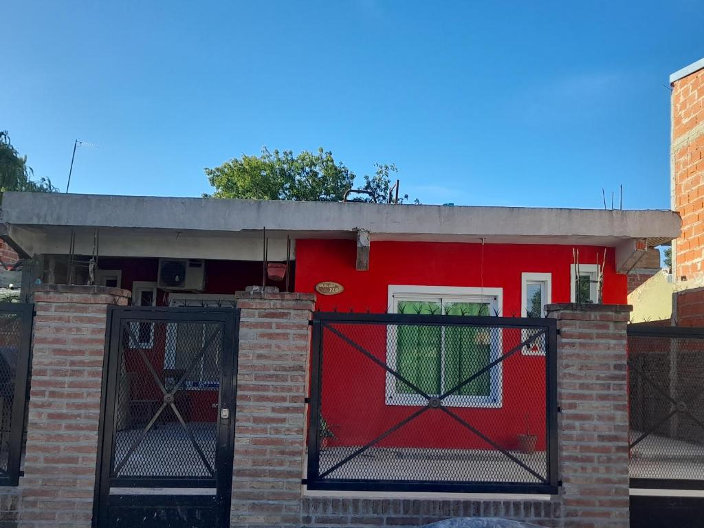 un edificio rosso con un cancello e una porta rossa di Departamento para 4 personas en ezeiza a Ezeiza