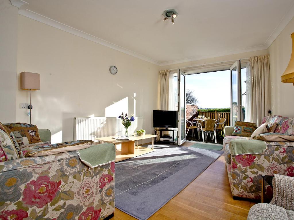 uma sala de estar com dois sofás e uma televisão em 1 Roundham Heights em Paignton