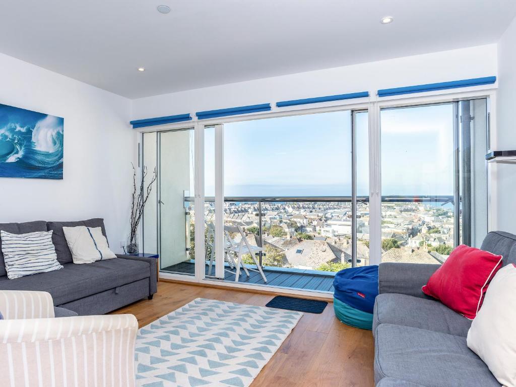 a living room with a couch and a large window at Above Towan At 8 Quay Court in Newquay