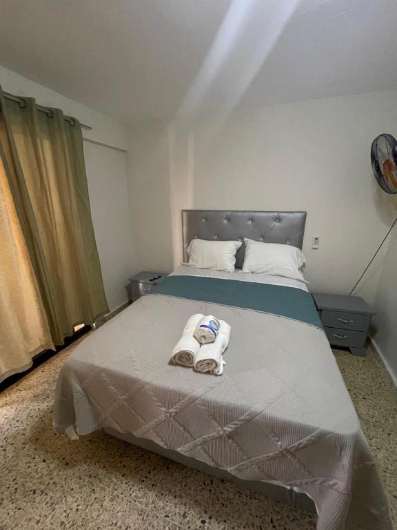 a bedroom with a bed with two towels on it at 2cristian suit in Los Frailes