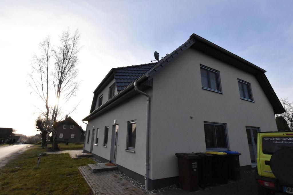 uma casa branca com um telhado preto em Ferienhaus Cappuccino auf der Insel Rügen em Lauterbach