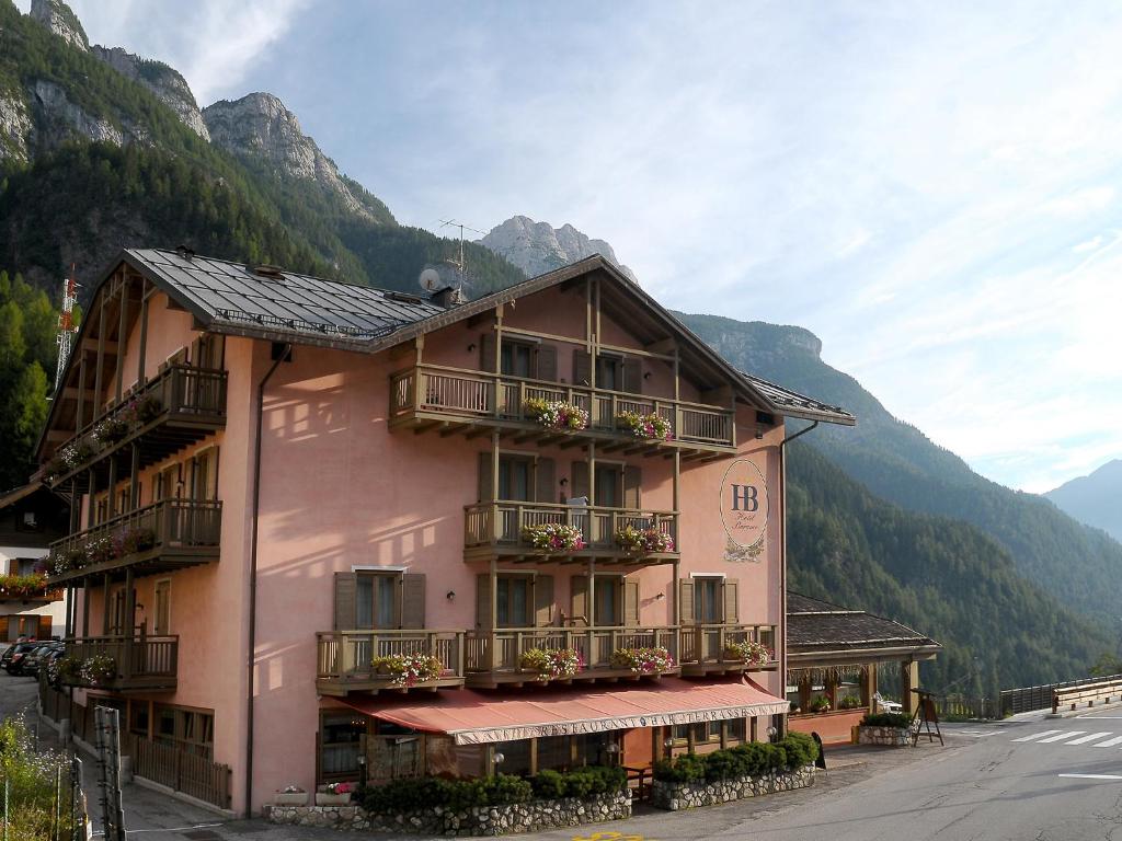 a pink building with flowers on the balconies of it at Hotel Barance in Alleghe