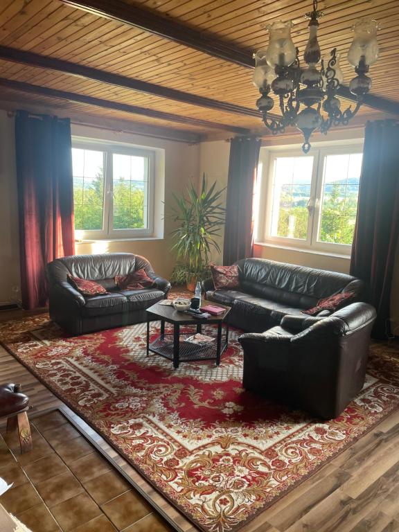 a living room with two leather couches and a table at Willa Toskania in Lądek-Zdrój