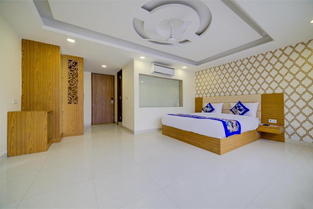 新德里的住宿－Hotel Decent Suites - Delhi Airport，一间设有床铺和天花板的大卧室