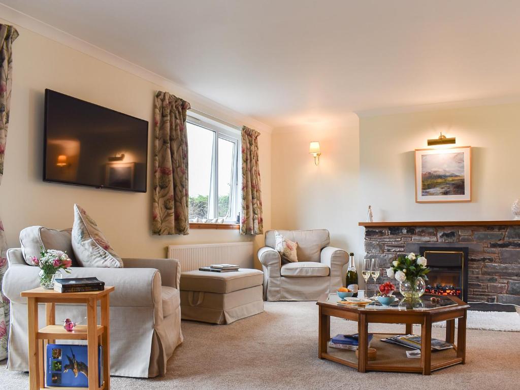 a living room with a couch and a fireplace at Carron View in Strathcarron