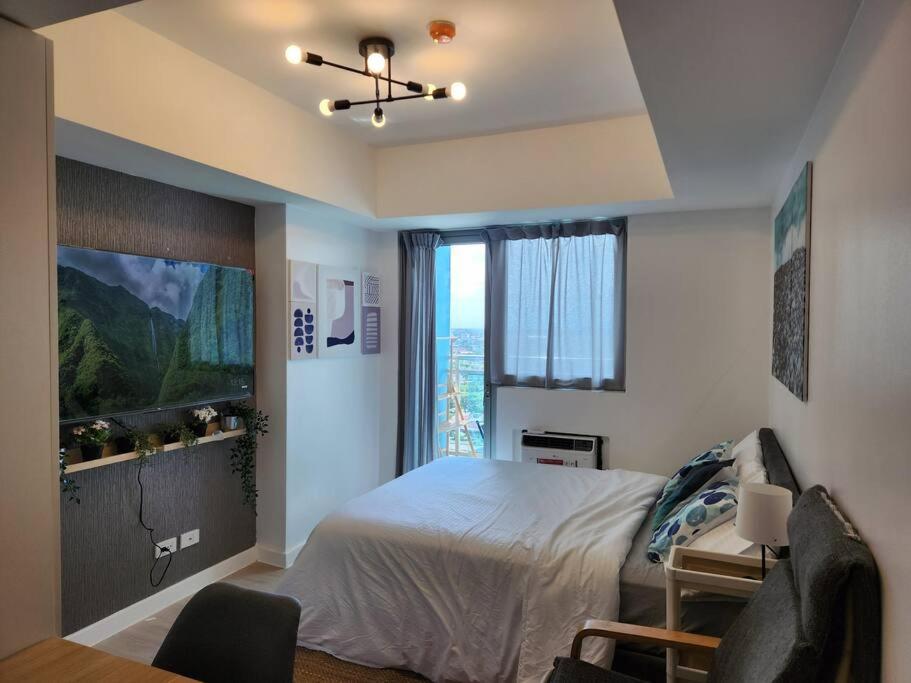 ein Schlafzimmer mit einem Bett und einem großen Fenster in der Unterkunft Amenity View Studio Azure North in San Fernando
