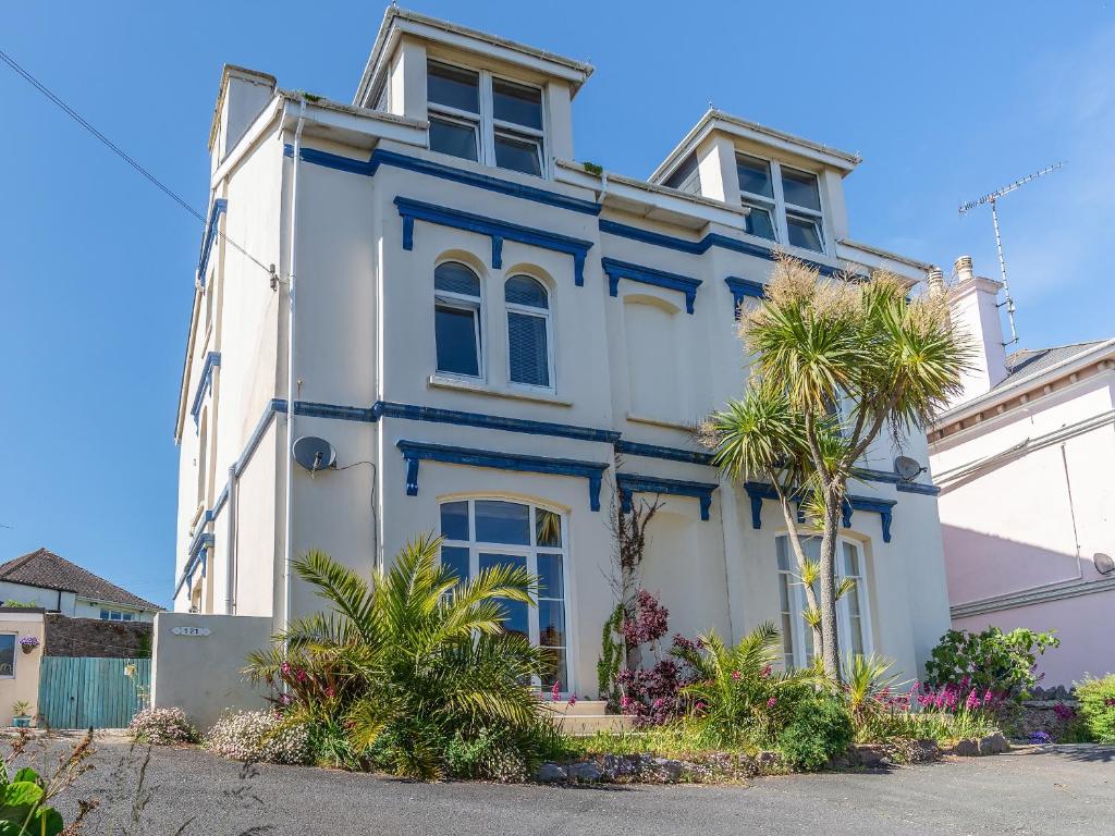 a blue and white house with a palm tree at Porto Seguro in Brixham