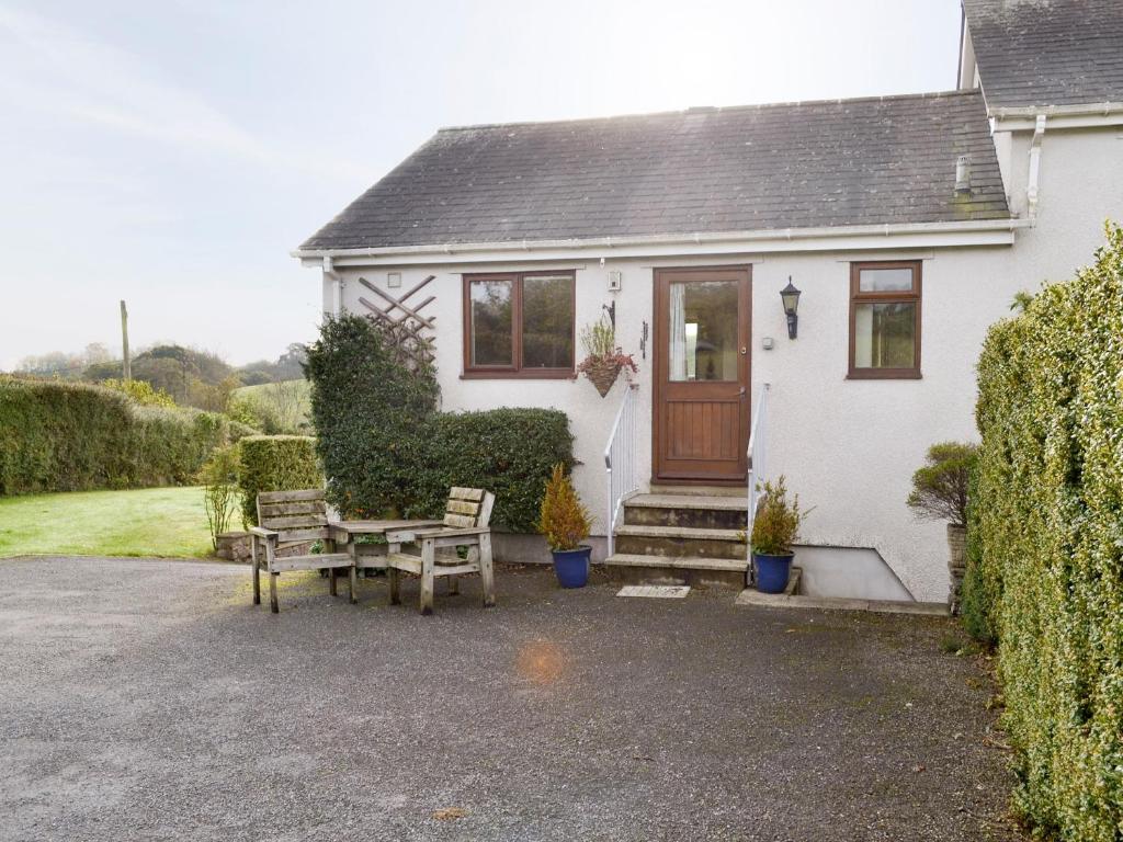 uma casa branca com uma mesa e um banco à sua frente em Champernowne em Darlington