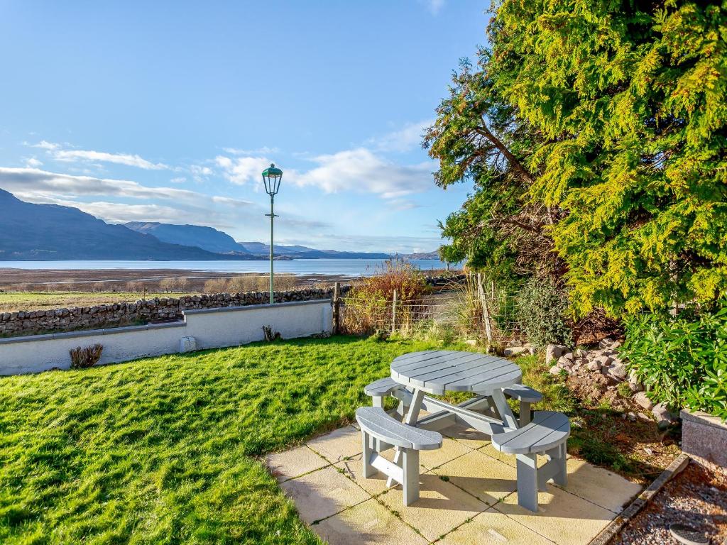 a picnic table in the grass with a view of the water at West Home in Torridon