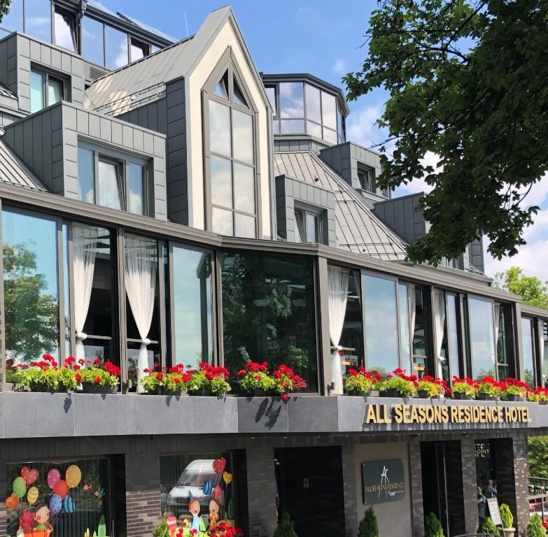 un edificio con ventanas y flores delante de él en All Seasons Residence Hotel - Free parking en Sofía