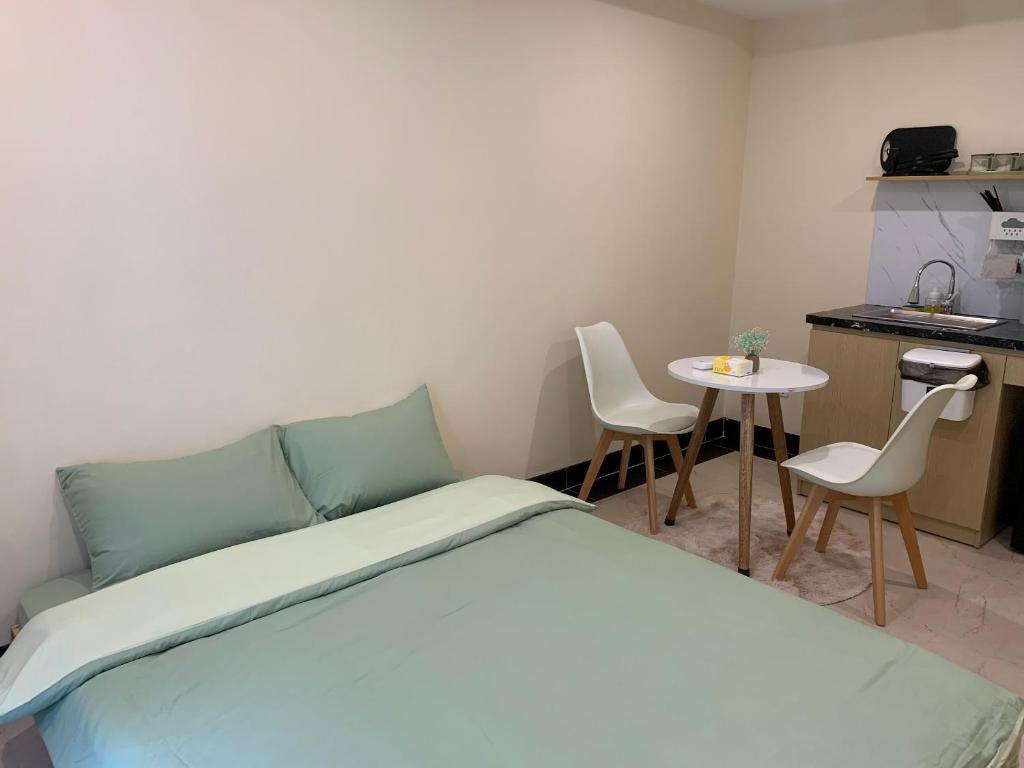 1 dormitorio con 1 cama, mesa y sillas en Mino Homestay, en Hanói