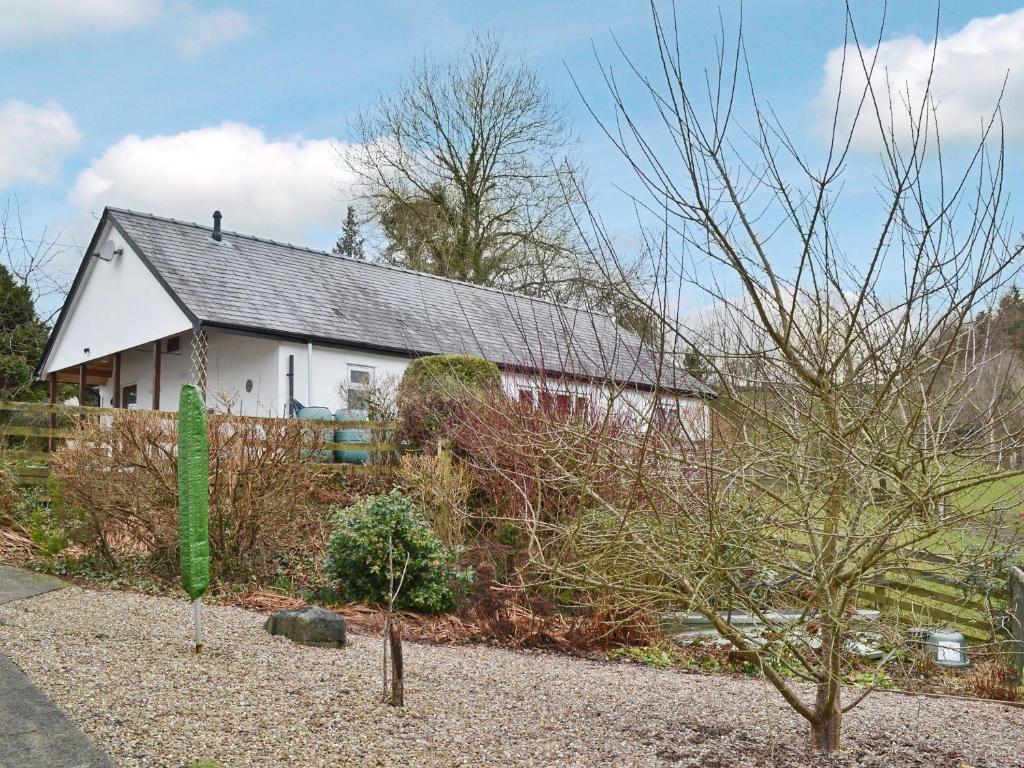 ein weißes Haus mit einem grünen Schild davor in der Unterkunft Blackbird Cottage in Llanfair Caereinion