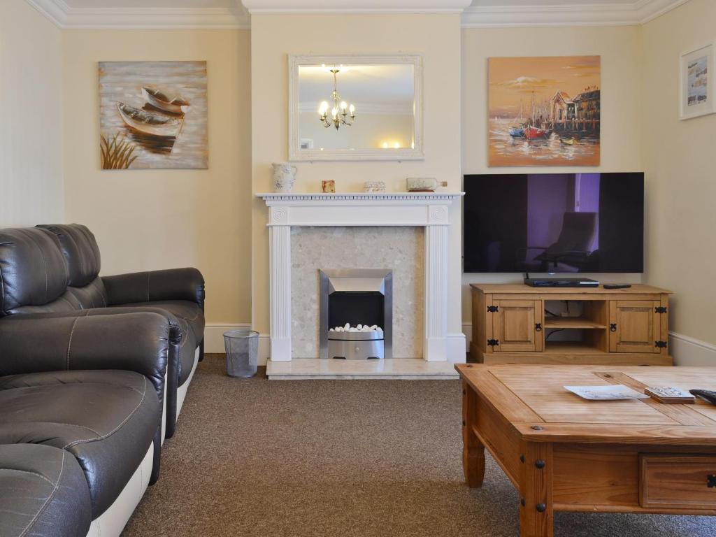 a living room with a couch and a fireplace at Filey House in Sheringham