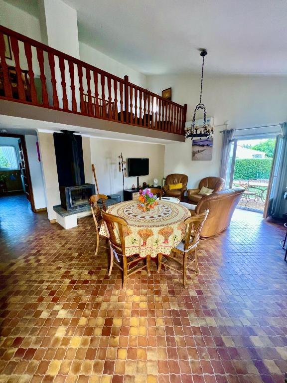 un salon avec une table et des chaises dans l'établissement Les orangers - Villa catalane avec Jacuzzi, à Saint-Génis