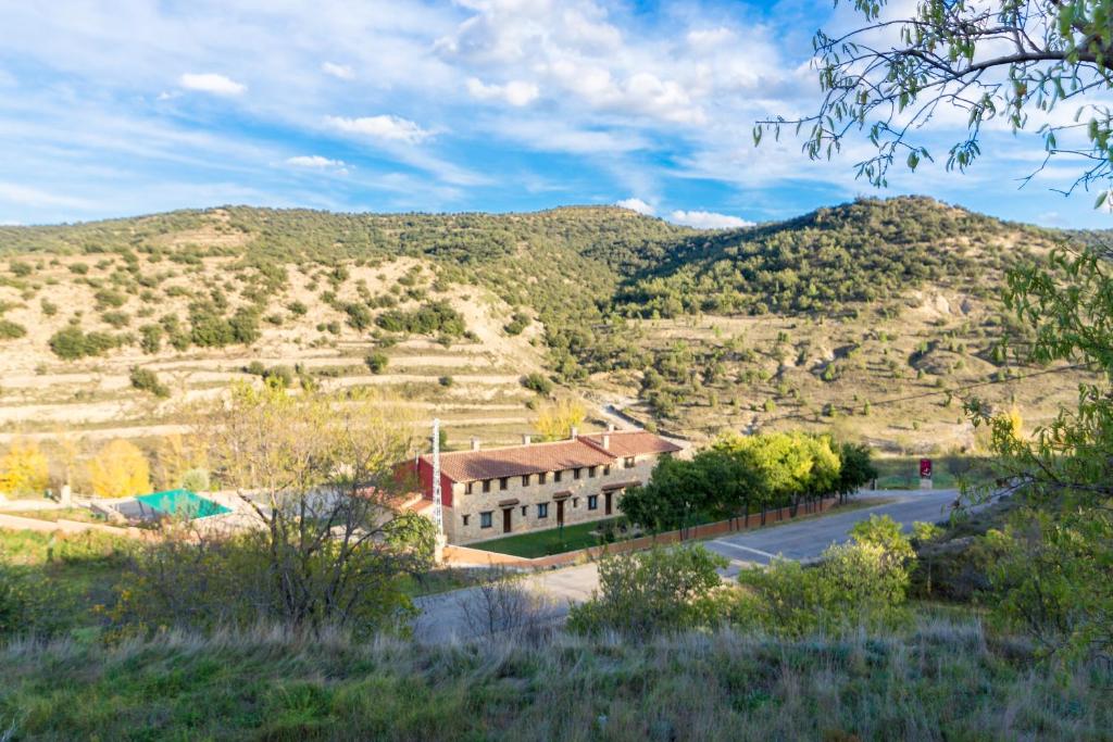 a building on a road with a mountain in the background at Hotel el Cantón Rural in La Cuba