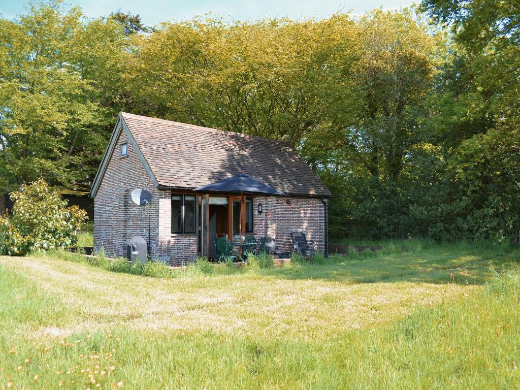 een oud stenen huis in het midden van een veld bij The Cowstall in Framfield