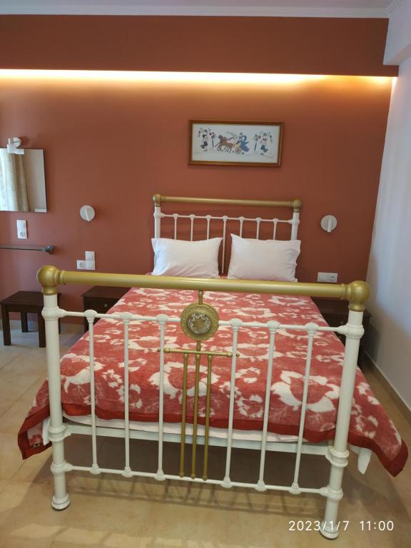 a bedroom with a bed with a red wall at Gerekos Studios and Apartments in Agios Georgios