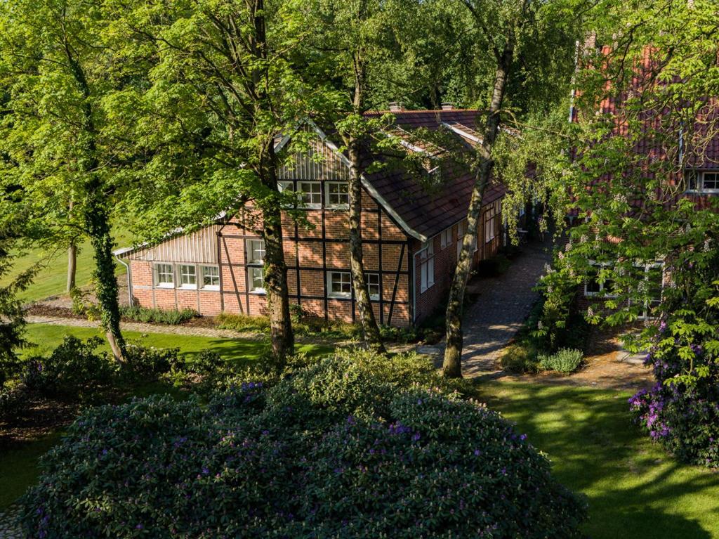una casa en medio de un patio con árboles en Thuers im Busch - Beste Stube en Münster