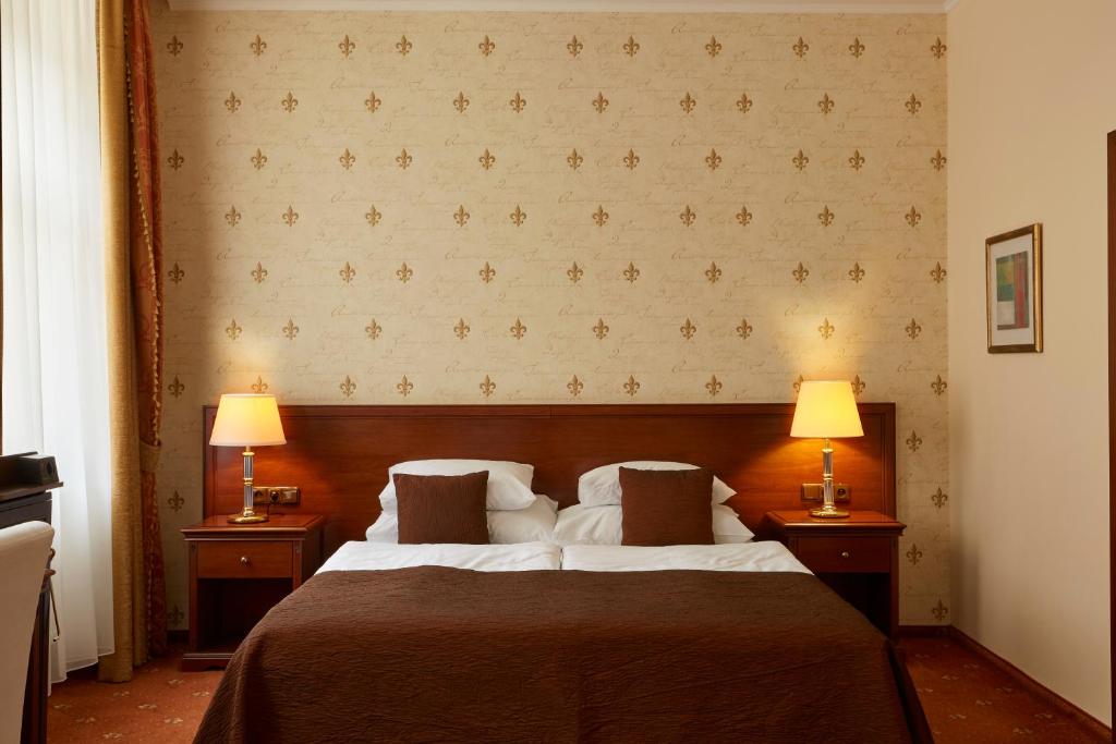 a bedroom with a large bed with two lamps at FLEUR DE LIS HOTEL in Prague