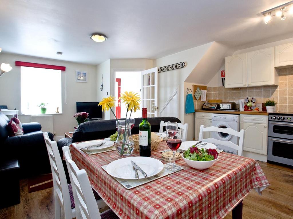a kitchen and living room with a table with a table cloth at Applebee Cottage in Bridport