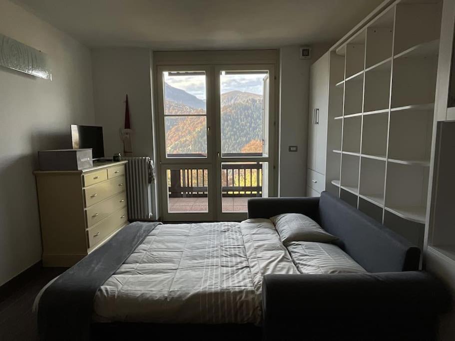1 dormitorio con cama y ventana grande en UNO SGUARDO SULLA NATURA, en Prato Nevoso