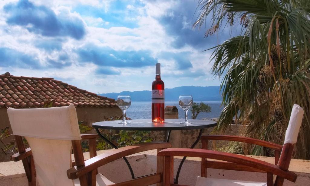 uma garrafa de vinho sentada numa mesa com dois copos em Menexes Suites Monemvasia em Monemvasia