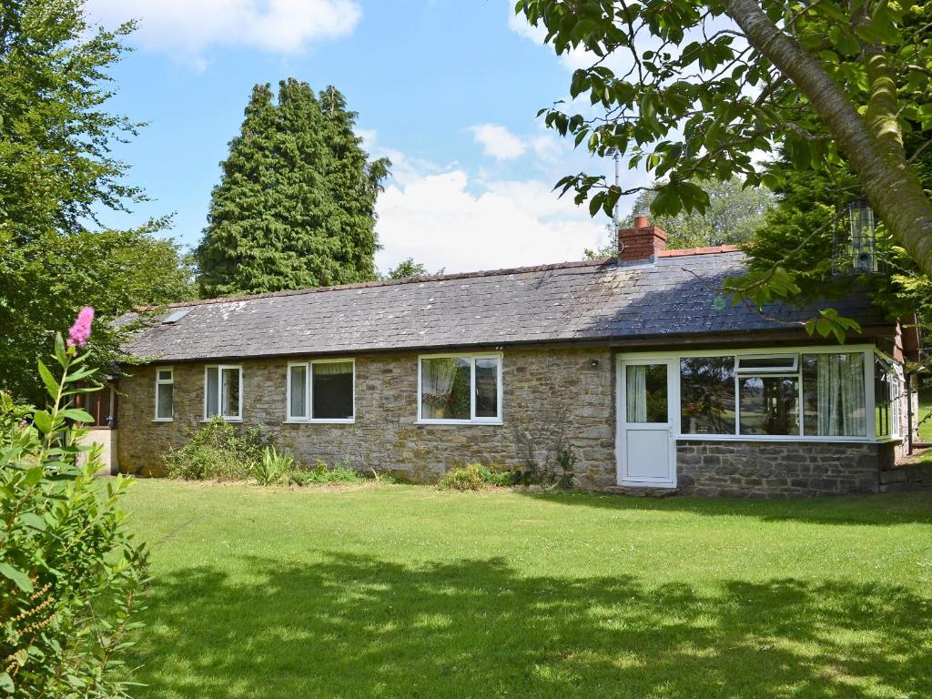 a brick house with a white door and a yard at Steep Holm in Kington