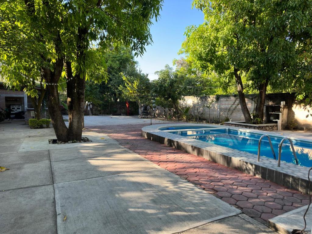 a swimming pool in a yard with trees at Casa Capistrano in Iguala de la Independencia