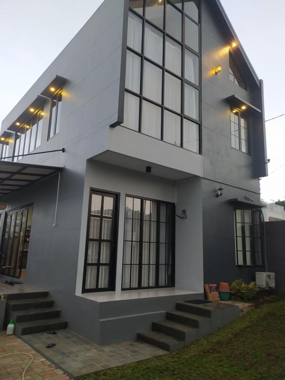 Una casa blanca con ventanas y escaleras. en Villa Sky Garden, en Bogor